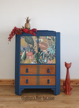 Blue tallboy cupboard, drawers below, with jungle-patterned découpage