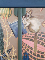 Blue tallboy cupboard, drawers below, with jungle-patterned découpage