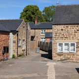 Looking down through the courtyard, with buildings on either side, and the Godfrey's Ear a-board visible.