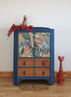 Blue tallboy cupboard, drawers below, with jungle-patterned découpage